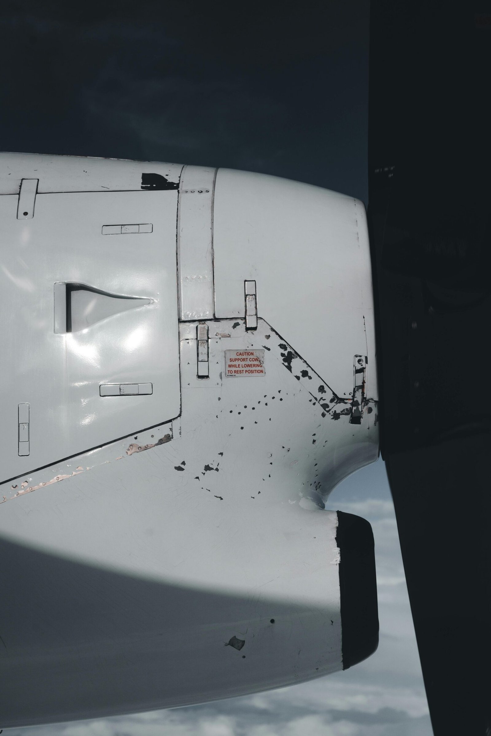 Detailed view of an airplane propeller and engine showing wear and use during flight.