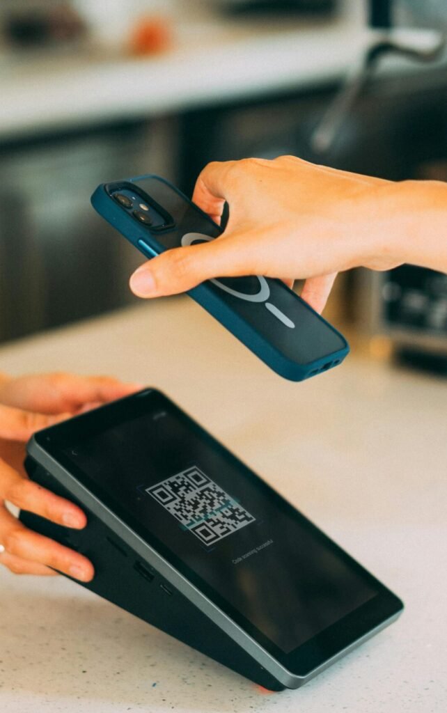 Close-up of a contactless payment using a smartphone and QR code scanner in a modern retail setting.